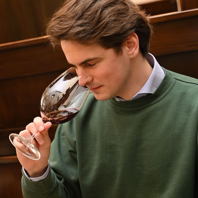 Ein Mann riecht an einem Glas mit Rotwein