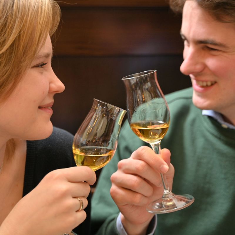 Ein Mann und eine Frau prosten sich mit Gläser mit Schnaps zu