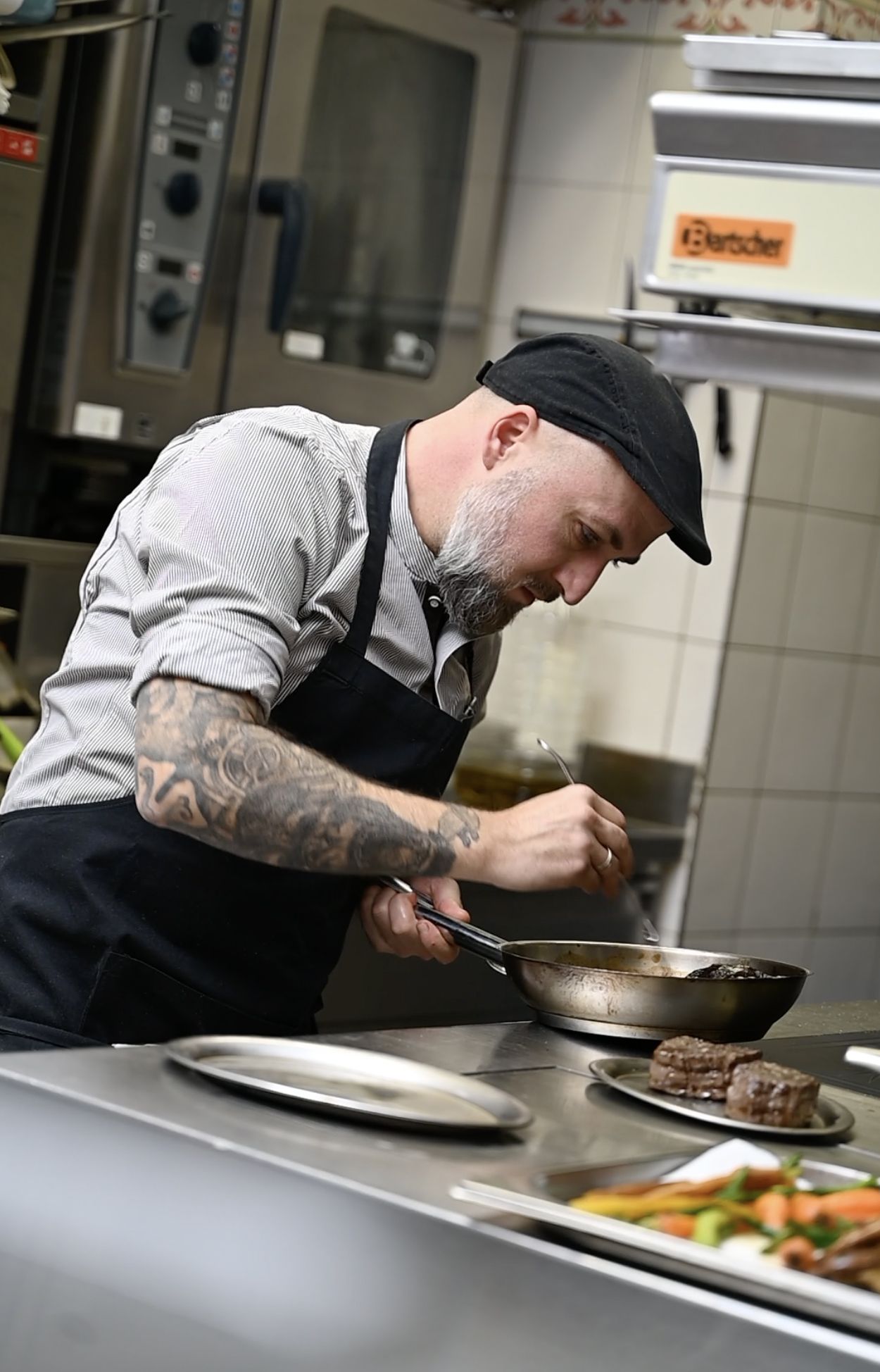 Matthias Schicht, der Küchenchef des Weißen Rauchfangkehrers hält eine Pfanne über den Herd